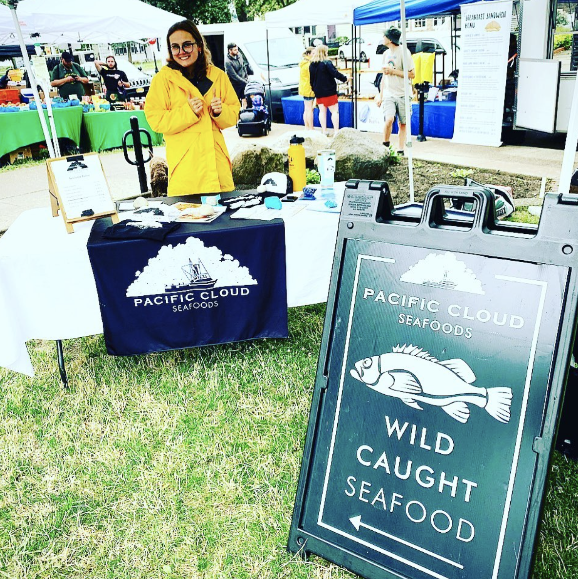 Grace setting up the Pacific Cloud Seafoods table at Kenmore Farmers Market
