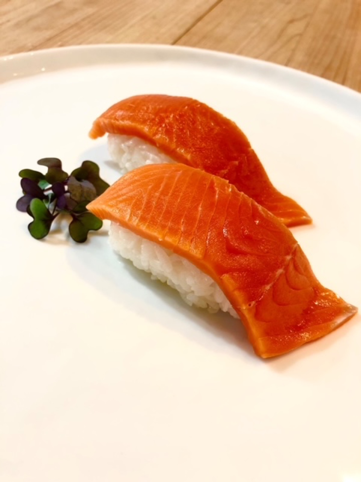 Salmon nigiri arranged on a white plate
